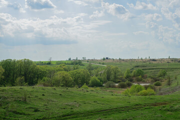 Fototapeta na wymiar Green hills with village houses, fields on the hills, harvest, summer