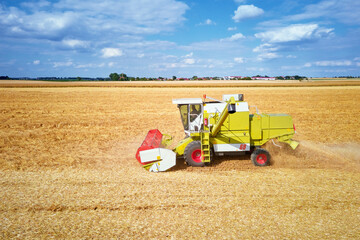 Combine harvester collecting golden wheat field, Harvesting machine working at agricultural field,...
