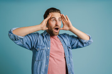 Young white man wearing shirt expressing surprise at camera