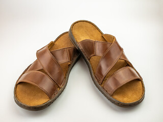 Men's sandals are brown leather flip-flops on a white background.