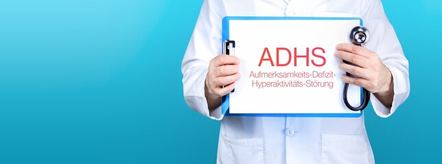 ADHS (Aufmerksamkeits-Defizit-Hyperaktivitäts-Störung). Arzt hält blaues Schild mit Papier. Wort...