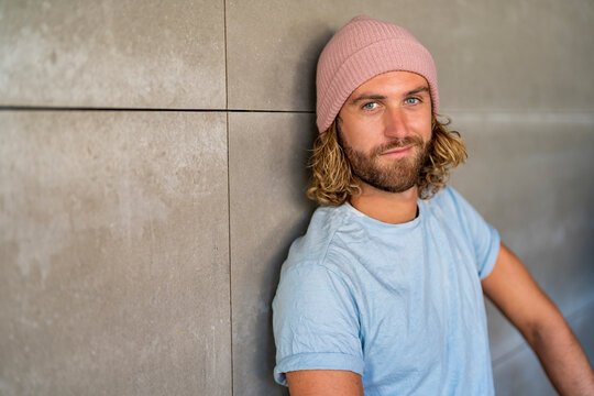 Confident man wearing knit hat by wall
