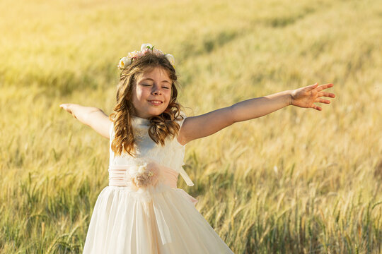 Smiling girl with arms outstretched in meadow