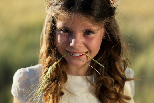 Smiling girl holding wheat crop in mouth