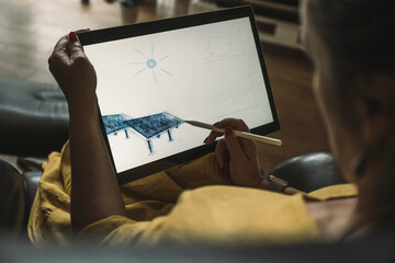 Engineer sketching solar panel on graphics tablet at home office