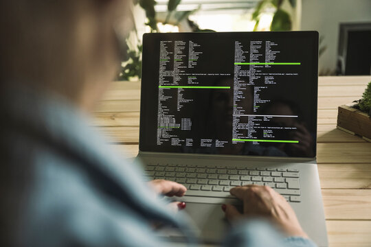 Computer programmer using laptop working at home office