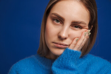 Young pensive girl propping her head looking in camera