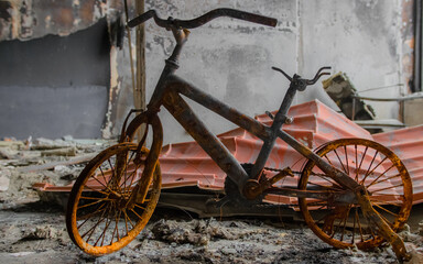 Irpin, Ukraine - May 22, 2022: a burned children's bicycle in a house destroyed by Russian troops...
