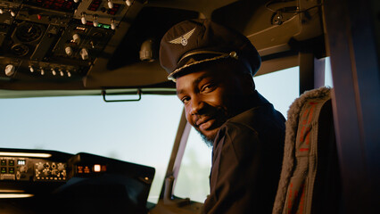 Portrait of male copilot pressing power switch buttons to takeoff and fly airplane, using control...