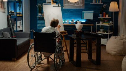Woman with chronic health condition drawing vase on canvas, using artistic skills to create artwork model. Wheelchair user with physical disability and impairment sketching authentic object.