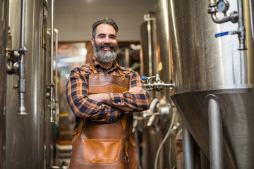 Portrait of man who is working at craft beer factory. Small family business, production of craft...