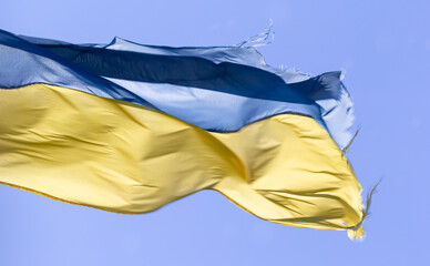 Ukrainian flag in the wind on blue sky background. Large national yellow blue flag of Ukraine. Big Ukrainian state banner