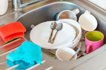 A lot of dirty dishes in the sink.Not washed dishes in the sink.Dishwashing liquid concept.