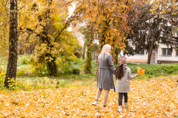 Fototapeta premium happy family mother and child daughter play and laugh at the autumn walk. Mother and child relations. Fashionable mother and daughter in a stylish look with the same jackets