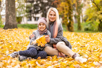 Fototapeta premium Mother and daughter in autumn yellow park.