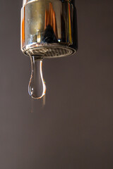 Tap from which drops of water flow. Drought, shortage, rationing and proper use of water.