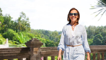 travel, tourism and vacation concept - happy smiling woman walking over terrace in thailand on background © Syda Productions