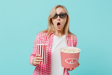 Young amazed woman in 3d glasses watch movie film hold bucket of popcorn cup of soda pop isolated...