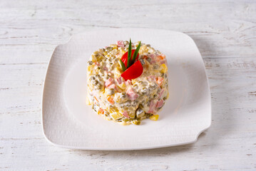 olivier salad. on a white wooden background