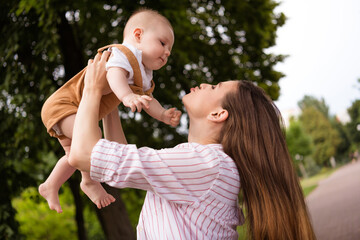 Obraz premium Photo of lovely sweet mom hold her baby kiss enjoy countryside trip outside city town wear casual clothes