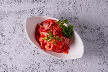 spicy achuchuk salad of tomatoes and onions. on a light concrete background