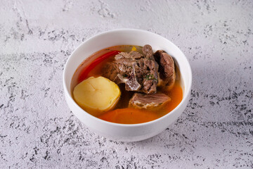 Shurpa soup with meat. on a light concrete background
