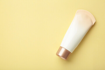 Tube of cream or gel white plastic product on beige background.