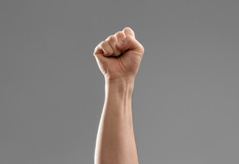 fight, aggression and gesture concept - close up of male hand showing fist or punching air over...