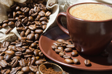 Espresso coffee on a background of coffee and ground beans on burlap.