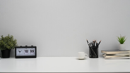 Home office desk with alarm clock, books, coffee cup and pencil holder. Copy pace for your...