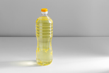 storage, food and culinary concept - close up of cooking rapeseed oil in plastic bottle on table - obrazy, fototapety, plakaty