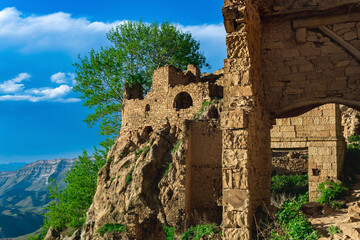 ruins of walls of houses on a cliff in the abandoned village of Gamsutl