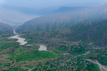 foggy mountain valley with river, villages and fields
