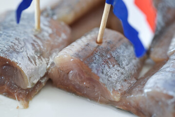 Den Helder, Netherlands. June 2022. Close up of raw herring with dutch flag and onions.