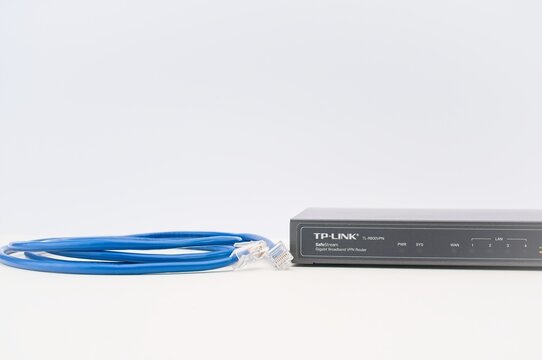 broadband network router with RG45 network cable on a white desk - industry and technology concept