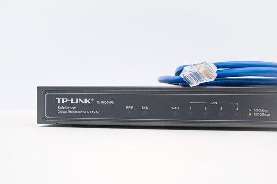 broadband network router with RG45 network cable on a white desk - industry and technology concept