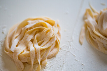 Homemade tagliatelle pasta folded in the shape of a nest. Home cooking of traditional Italian pasta.