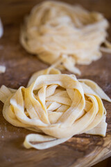 Homemade tagliatelle pasta folded in the shape of a nest. Home cooking of traditional Italian pasta.