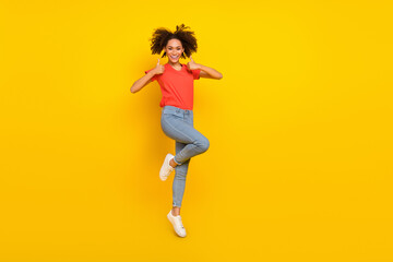 Fototapeta na wymiar Full body photo of excited attractive lady jump two hands demonstrate thumb up isolated on yellow color background