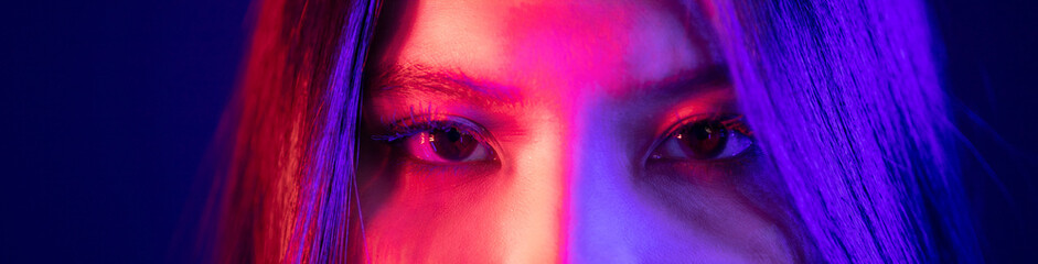 Stylish sexy woman in trendy. Beautiful young asian woman standing pose with neon light. Asia Pretty asian female in the dark room. Fashion shot.