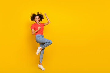 Fototapeta na wymiar Full length portrait of overjoyed positive girl raise fists celebrate triumph isolated on yellow color background