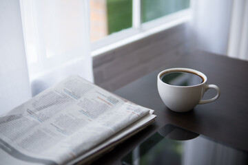 coffee cup and newspaper on office desk