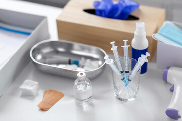 Fototapeta premium medicine and healthcare concept - close up of syringes, drug in jar and other stuff on table at hospital