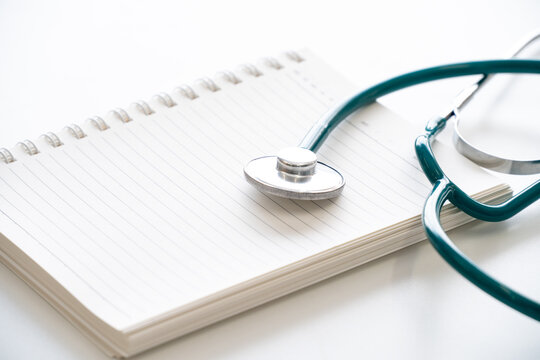 Stethoscope medical equipment on blank notebook,isolated on white background.