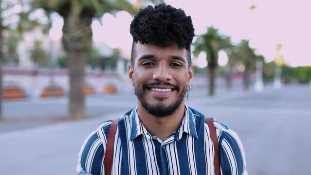 Face portrait of young hispanic latino man in city street - Happy millennial guy smiling at camera while standing outdoor