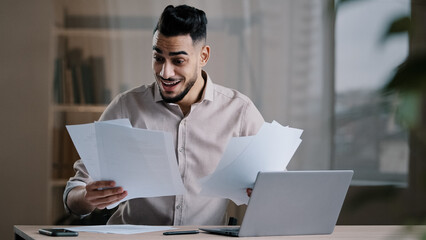 Happy arab man hispanic guy businessman read documents conclude successful commercial contract has...
