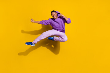 Fototapeta na wymiar Full length body size view of handsome trendy strong guy jumping fighting isolated on bright yellow color background