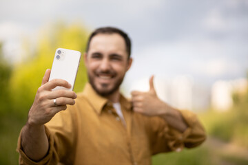 A man communicates on the phone online. Remote communication. Blogger. selfie Mobile Communication. A man is smiling while talking on the phone.