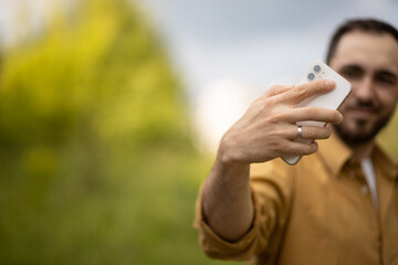 A man communicates on the phone online. Remote communication. Blogger. selfie Mobile Communication. A man is smiling while talking on the phone.