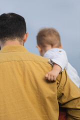 A father spends time with his son. Happy parenthood. A father and his son are walking in the field. The father is his toddler son.